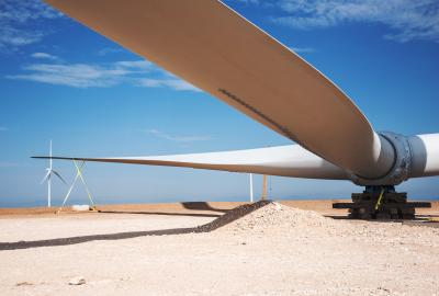 A massive wind turbine fan blade on the ground before it is installed