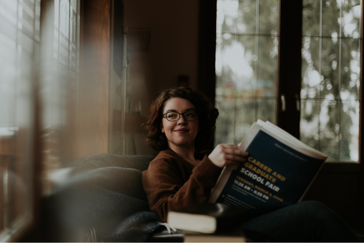 Women on her couch reading the newspaper