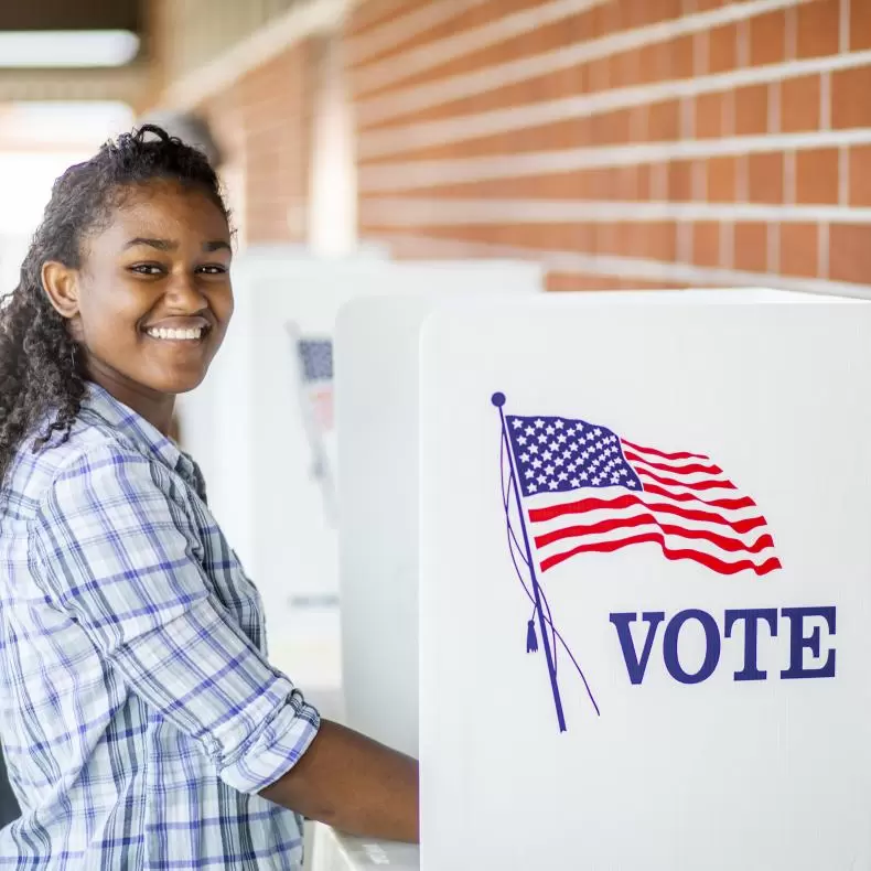 A young adult smiling while voting 