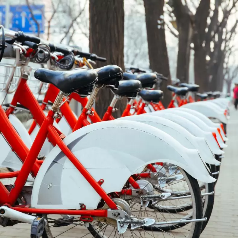A row of red bicycles that offer a carbon-free mode of transportation
