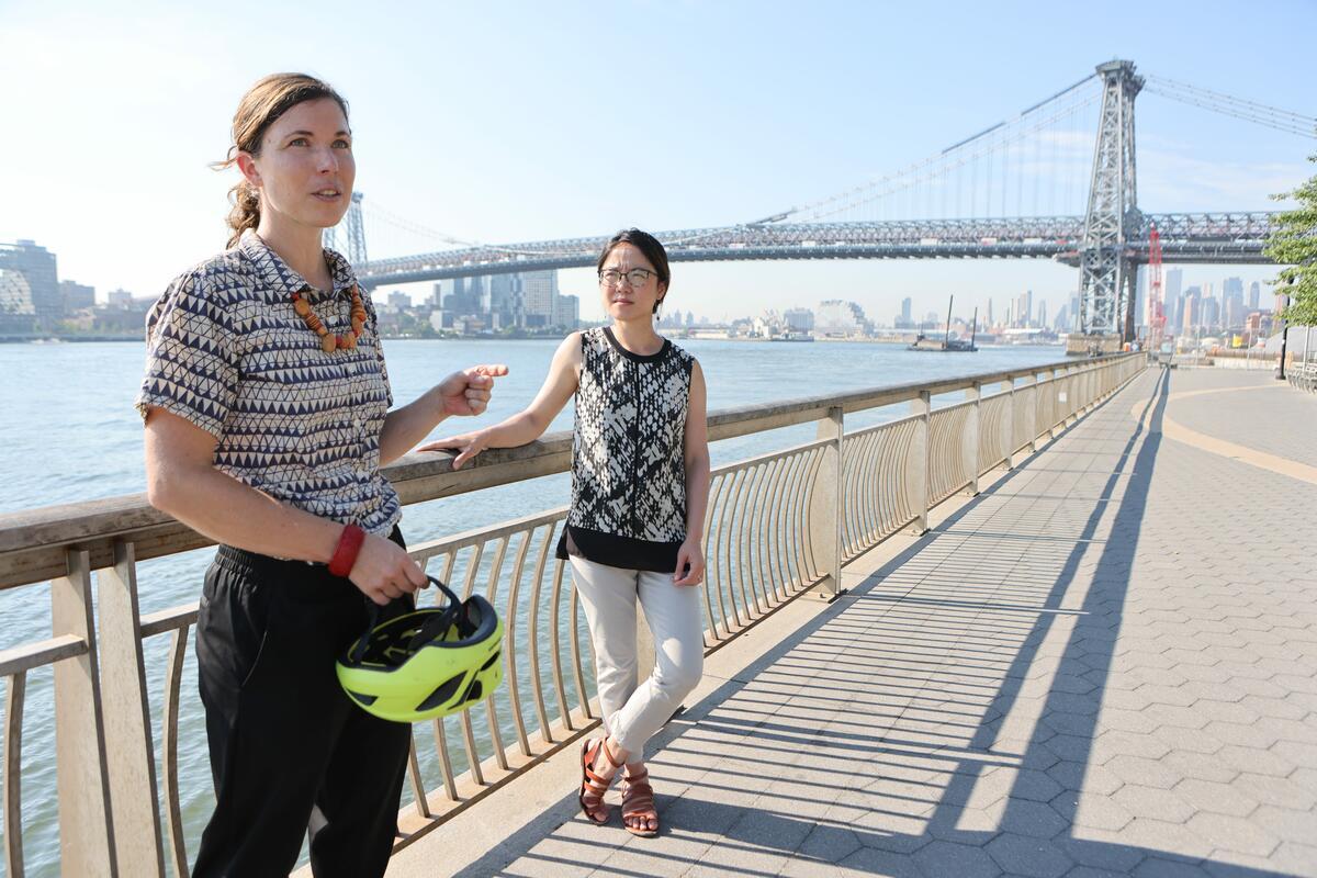 Kate Boicourt and Linda She standing on waterfront with bridge in the background