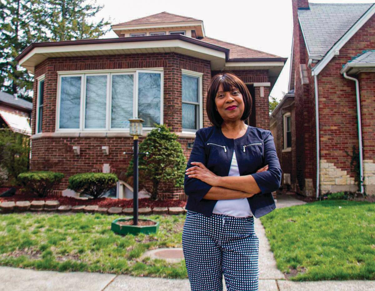 Cheryl Watson, who submitted testimony in a case about evaluating utility performance, stands in her front yard in Chatham, Illinois