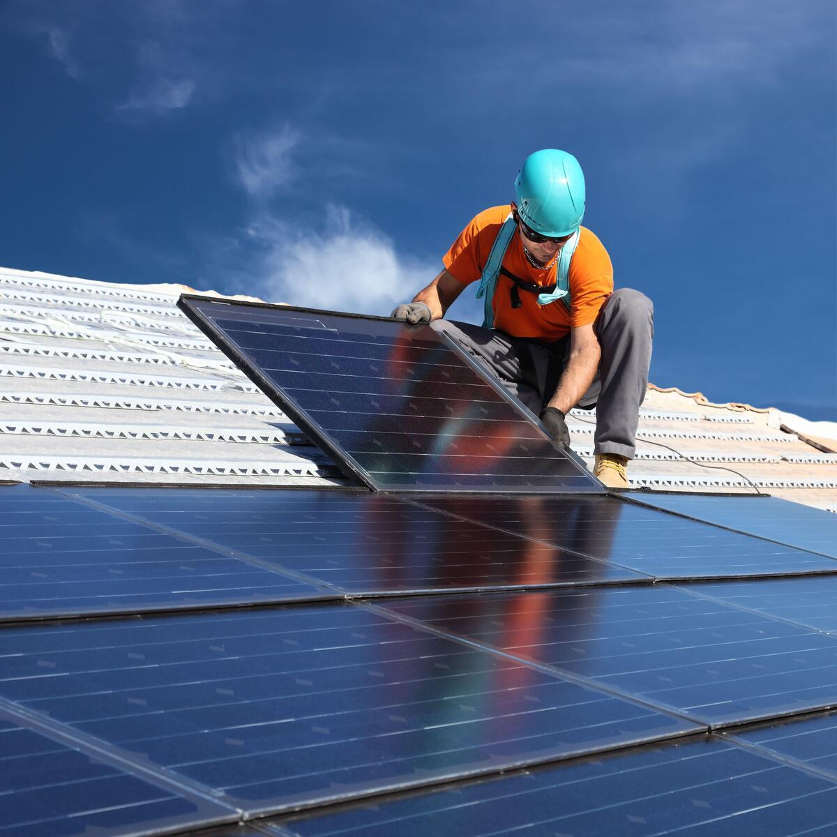 A contractor installing rooftop solar panels
