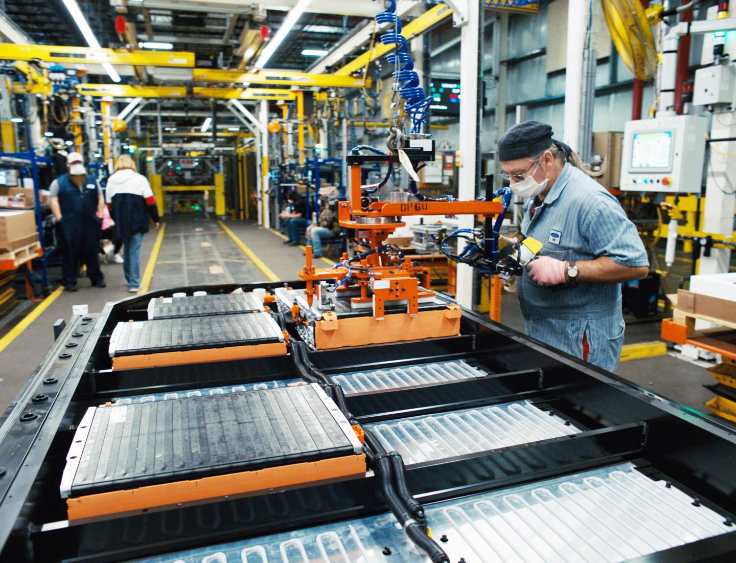 An autoworker on a Ford factory line working on electric vehicle batteries