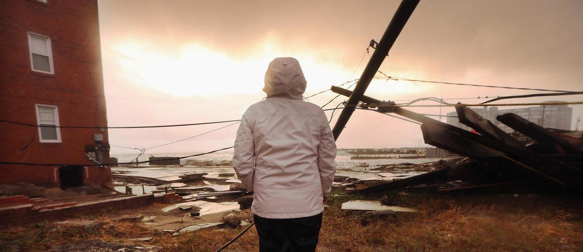 A person looks out at destruction after a hurricane