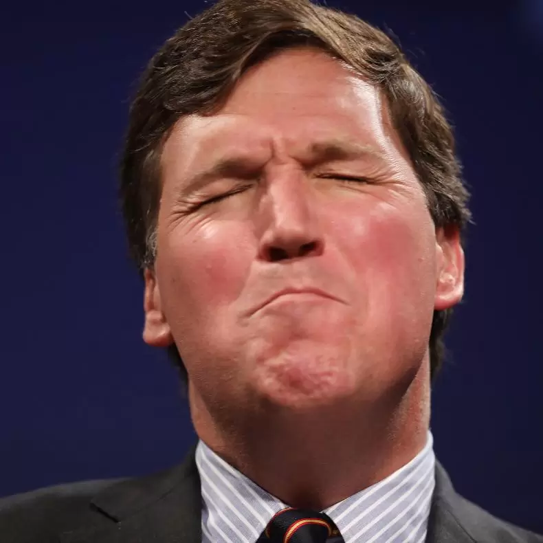 Closeup of Tucker Carlson's face, seemingly in pain