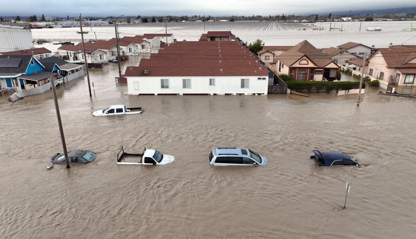 An aerial photograph of cars and homes engulfed by floodwaters