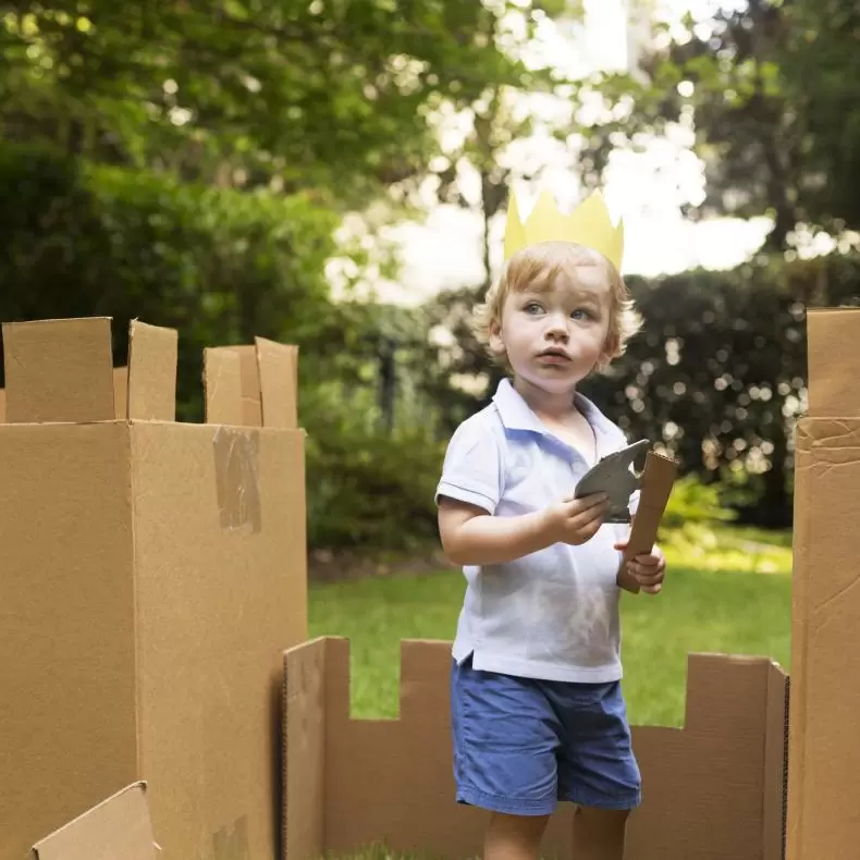 Child repurposing a cardboard box for imaginative play