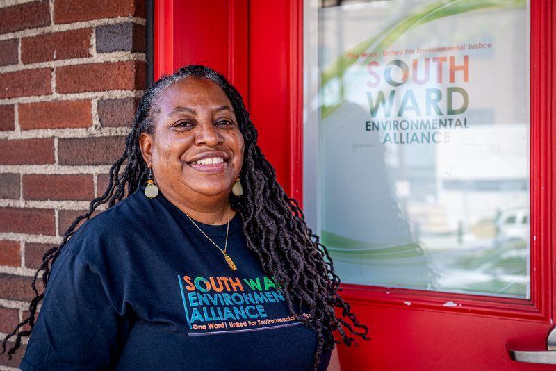 Kim Gaddy standing in front of a door with South Ward Environmental Alliance on it