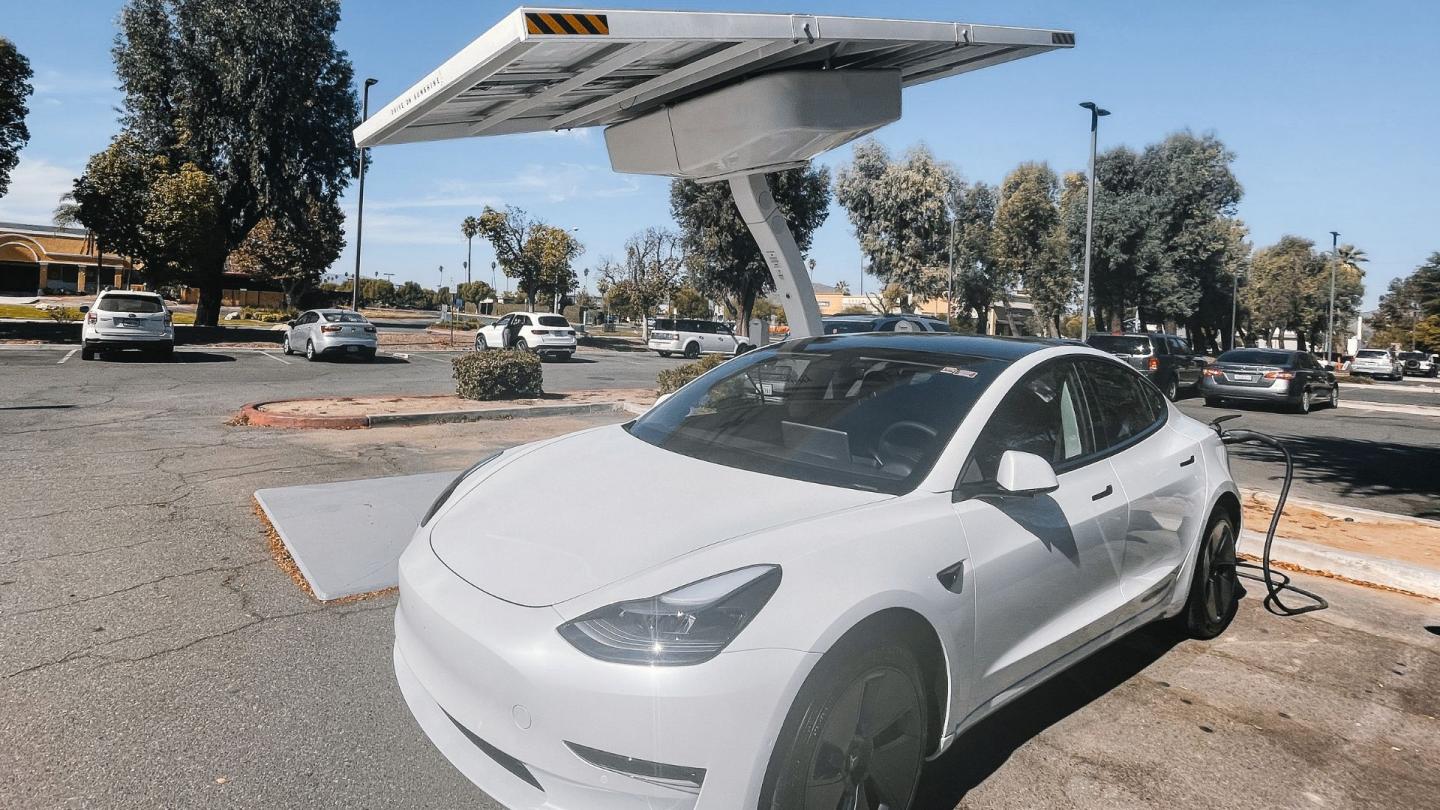 An electric car parked at a charging station in a parking lot