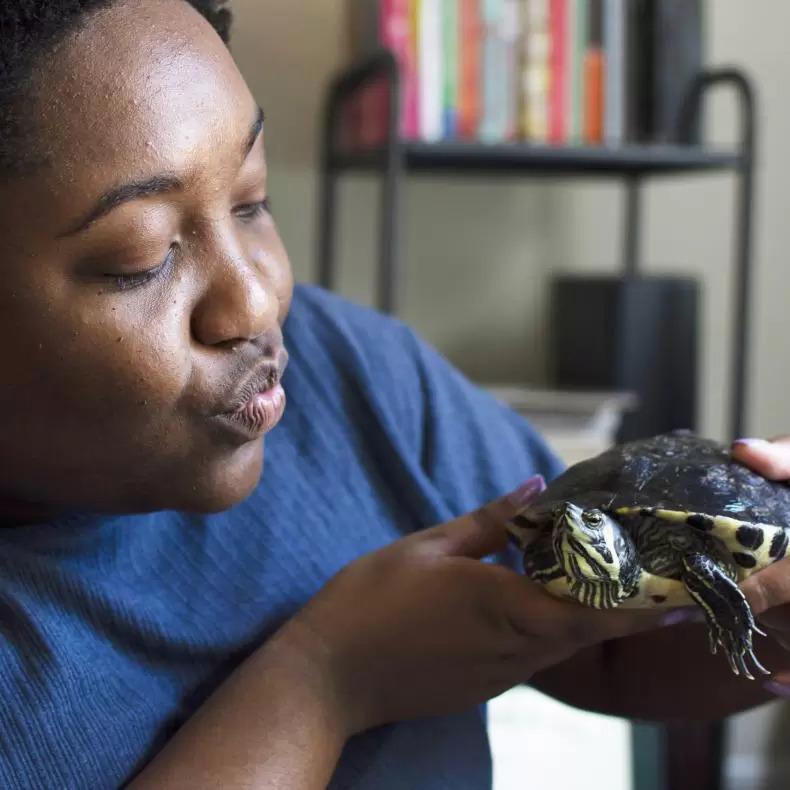 Lee Alisha Williams making a kissy face at her turtle who is also named Lee