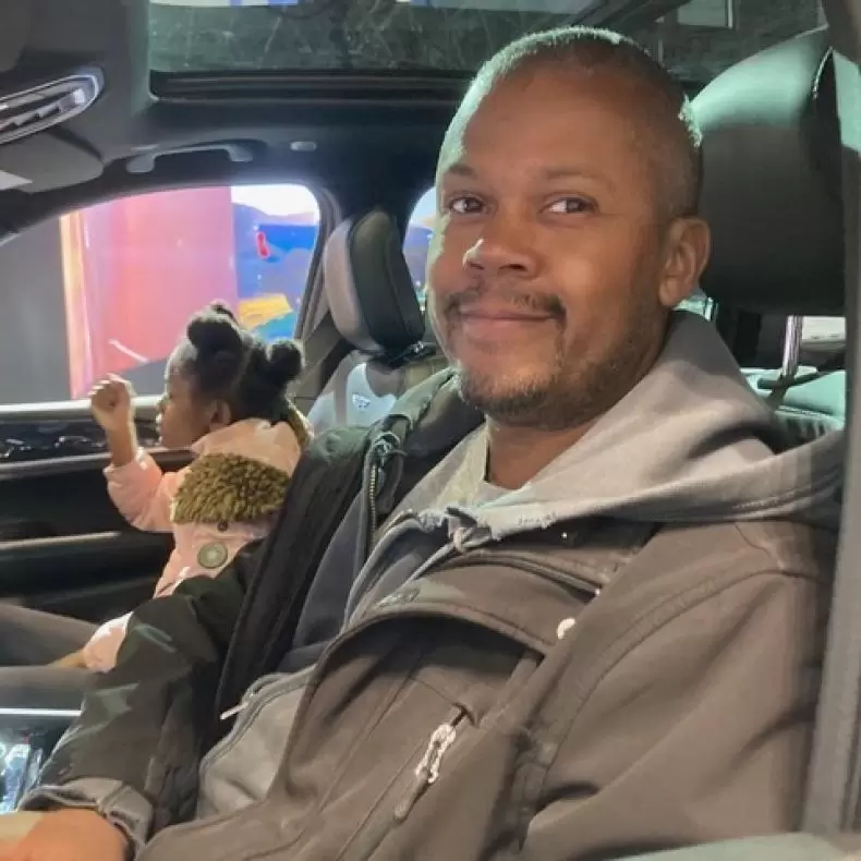 Father and daughter sitting in an electric vehicle at the New York auto show