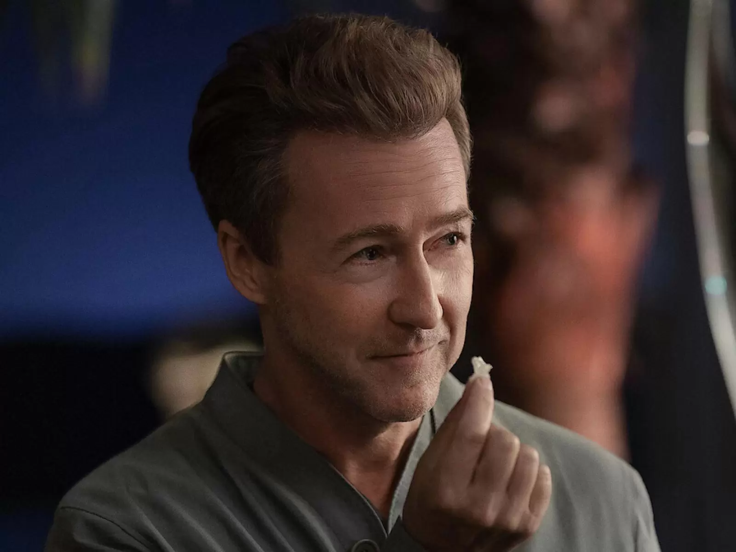 Movie still from Glass Onion, a closeup of Ed Norton holding a small hydrogen crystal in his hand.
