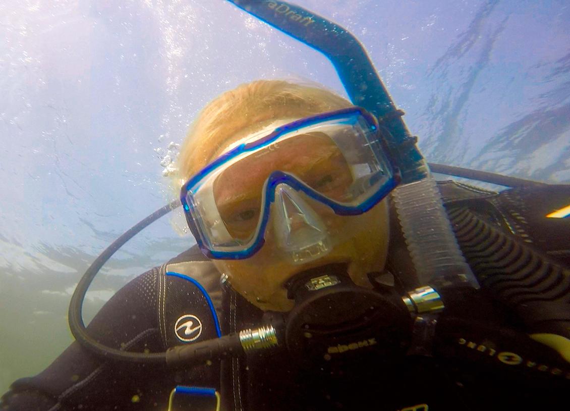 Leslie Von Pless underwater with a snorkel and goggles and breathing apparatus on which is apparently her headshot