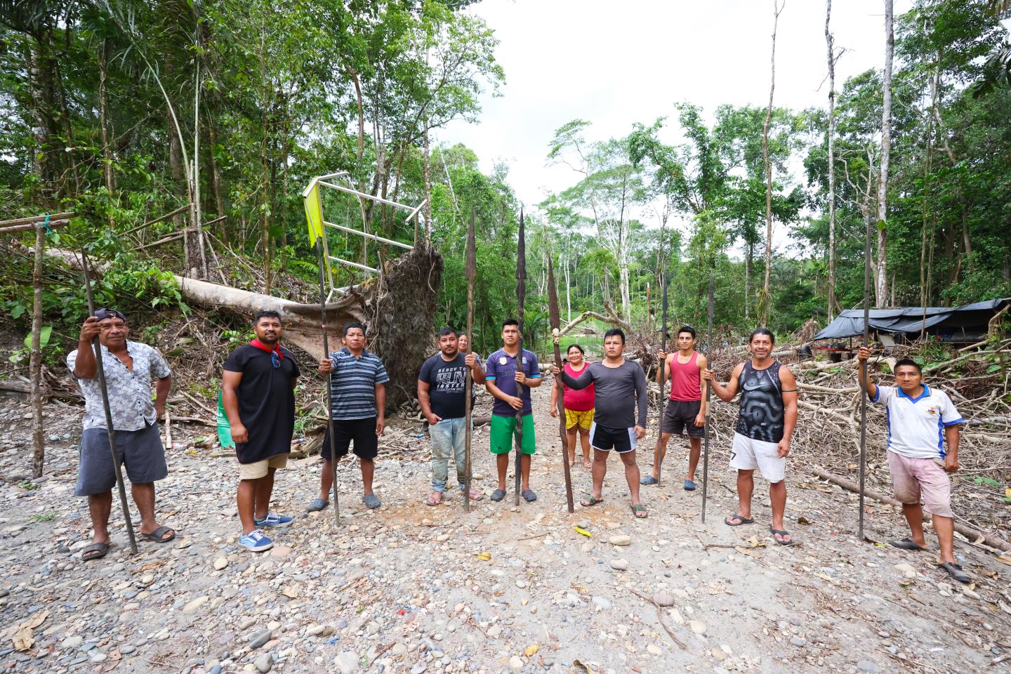 Indigenous people in the Amazon holding spears blocking a road
