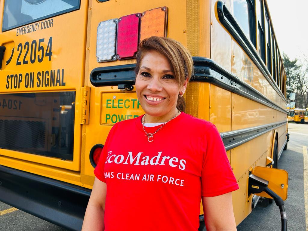 Carmen Cortez stands behind a school bus