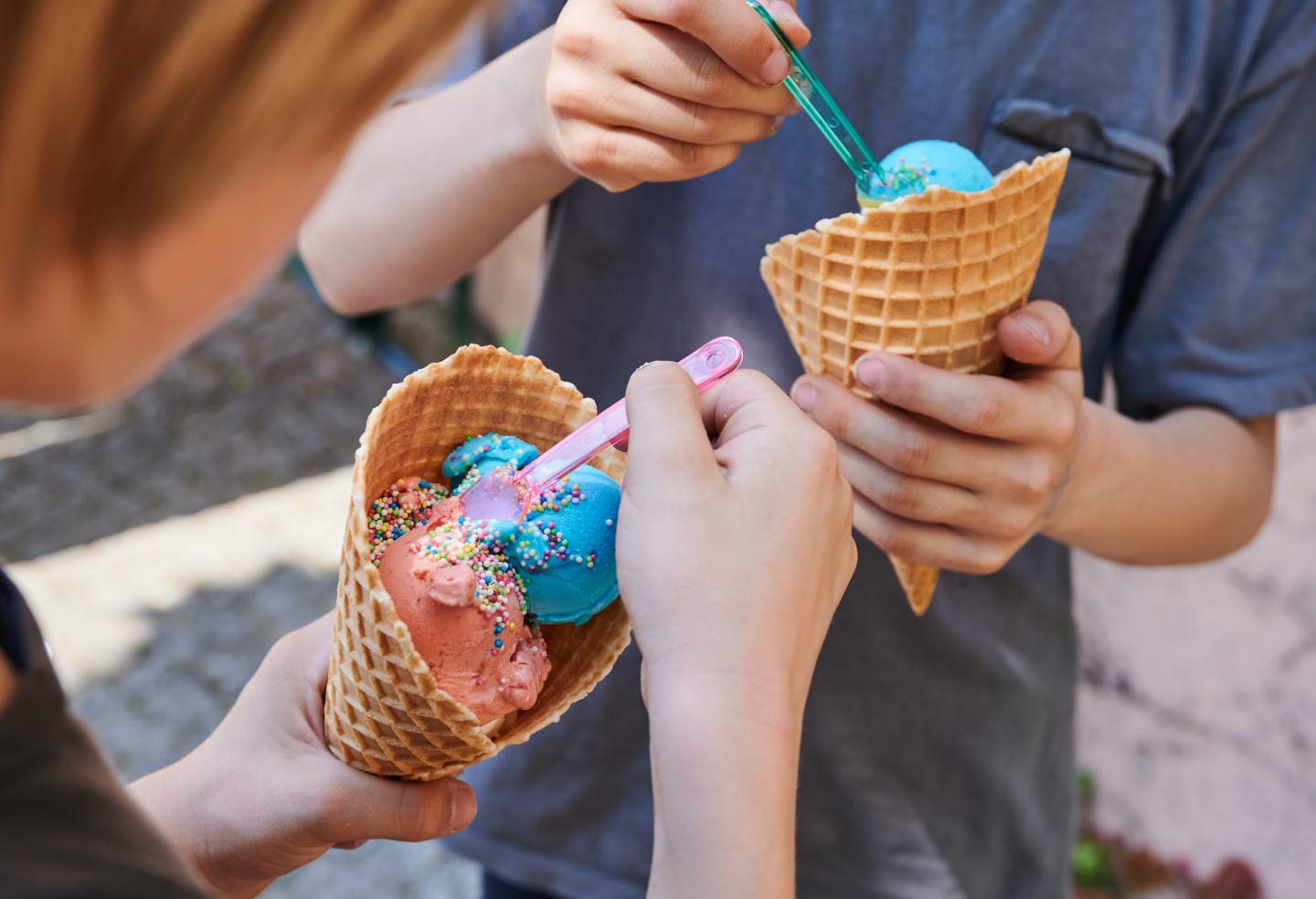 Two kids eating ice cream in waffle cones