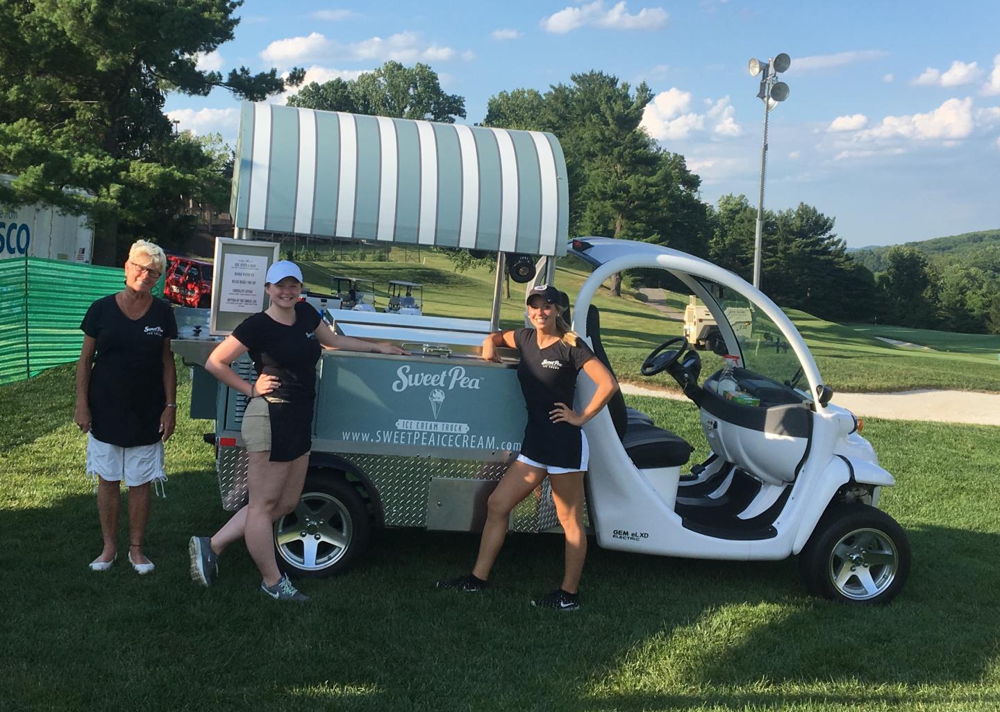 Three people standing by the Sweet Pea electric ice cream truck