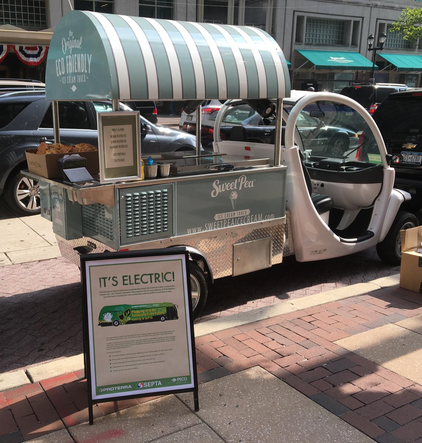 An electric ice cream truck sits parked on a busy city street