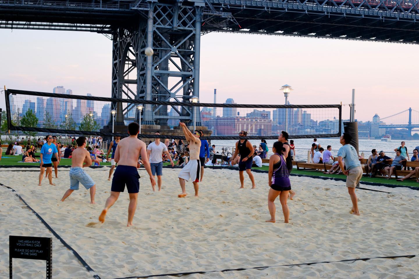 A group of people playing sand volleyball in New York City