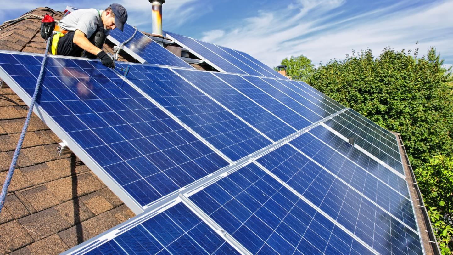 Workers installing solar panels on a rooftop