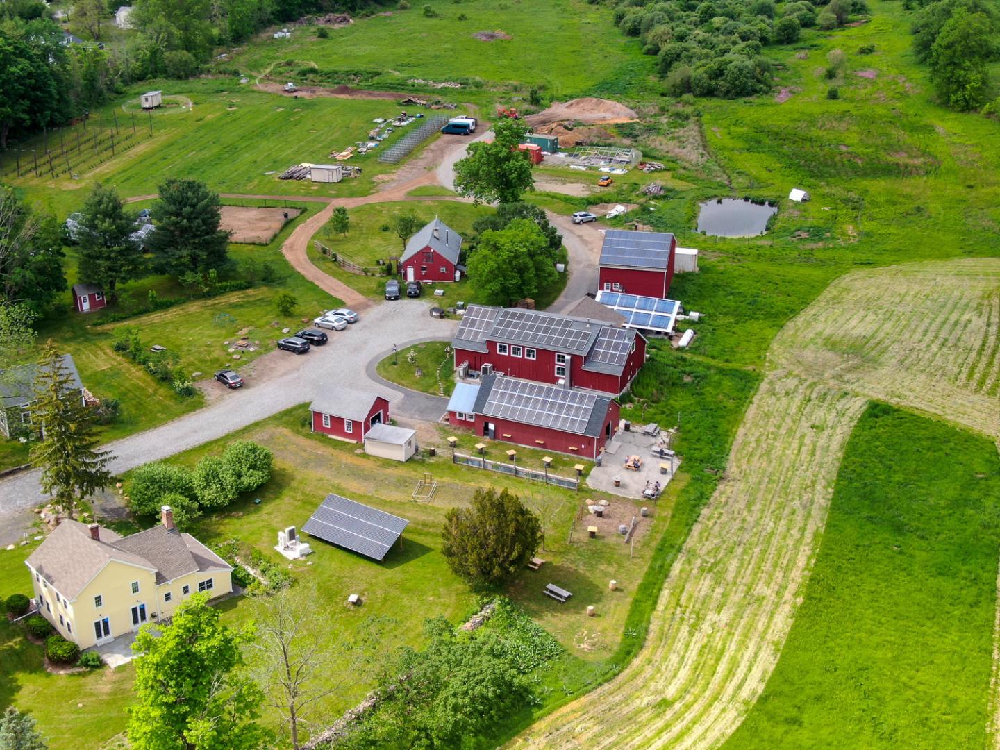A drone shot of farmhouses with solar panels covering the roofs