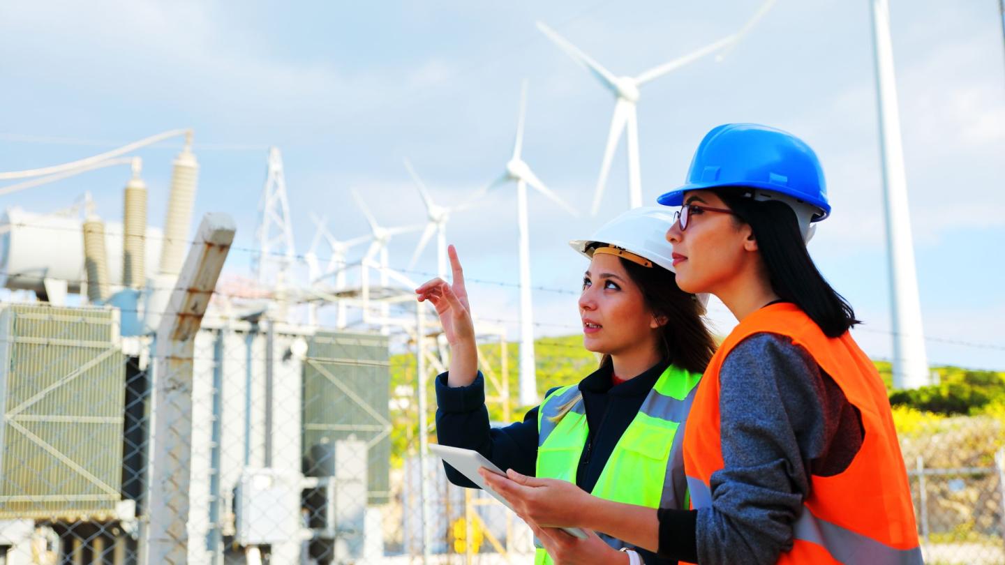 Two people inspecting a wind farm