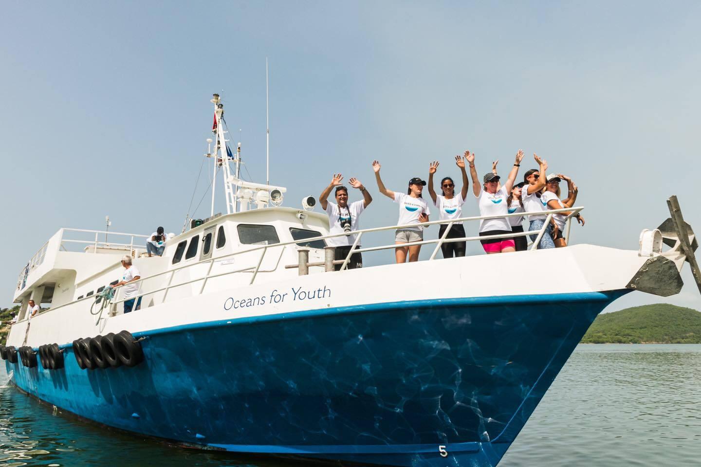 Researchers on the Bojeo a Cuba expedition wave from the bow