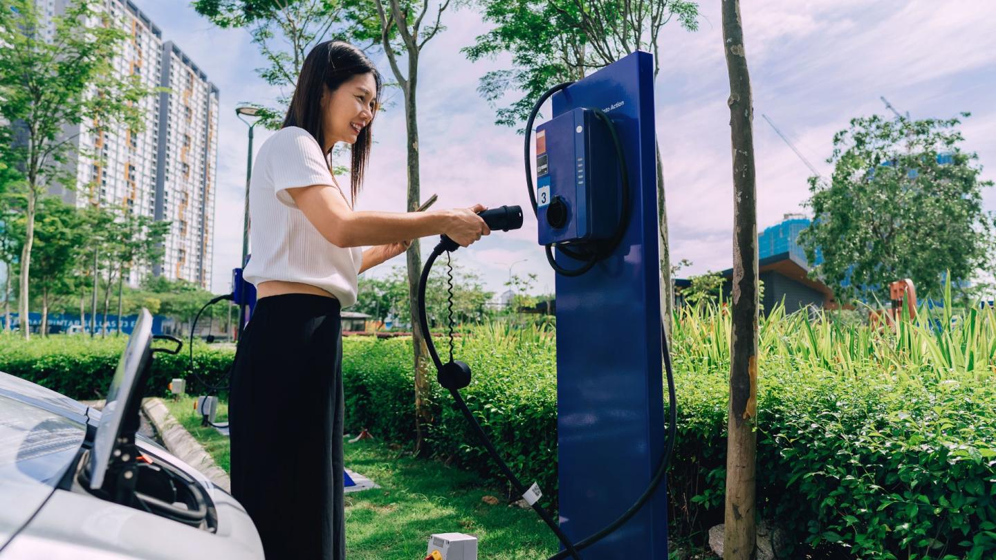 A person plugging their electric vehicle into a charger