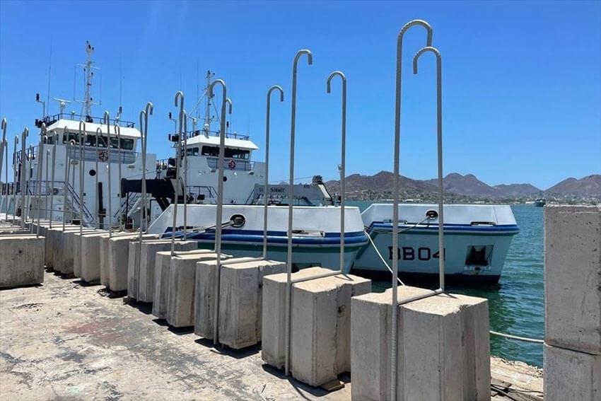 Large metal hooks attached to blocks of concrete which are used to stop gill nets