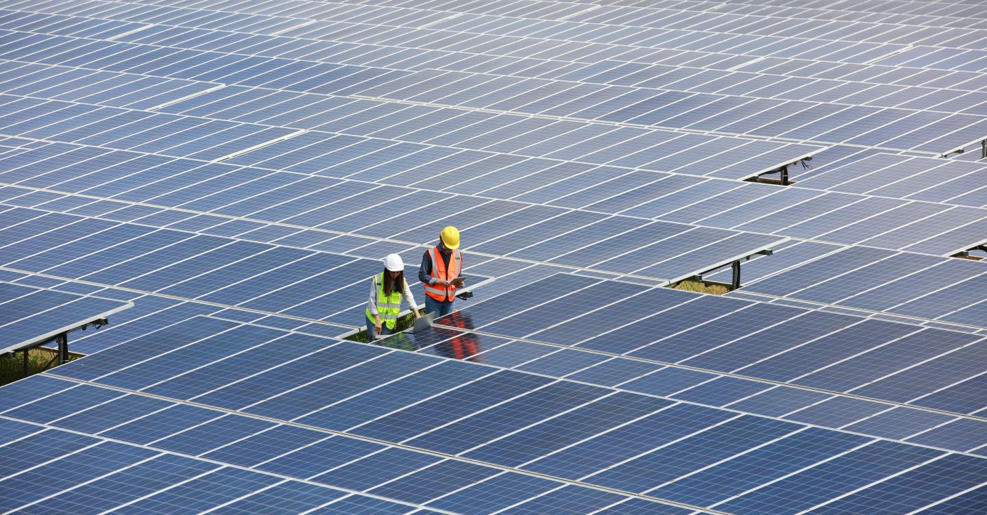 Two people inspecting a solar array