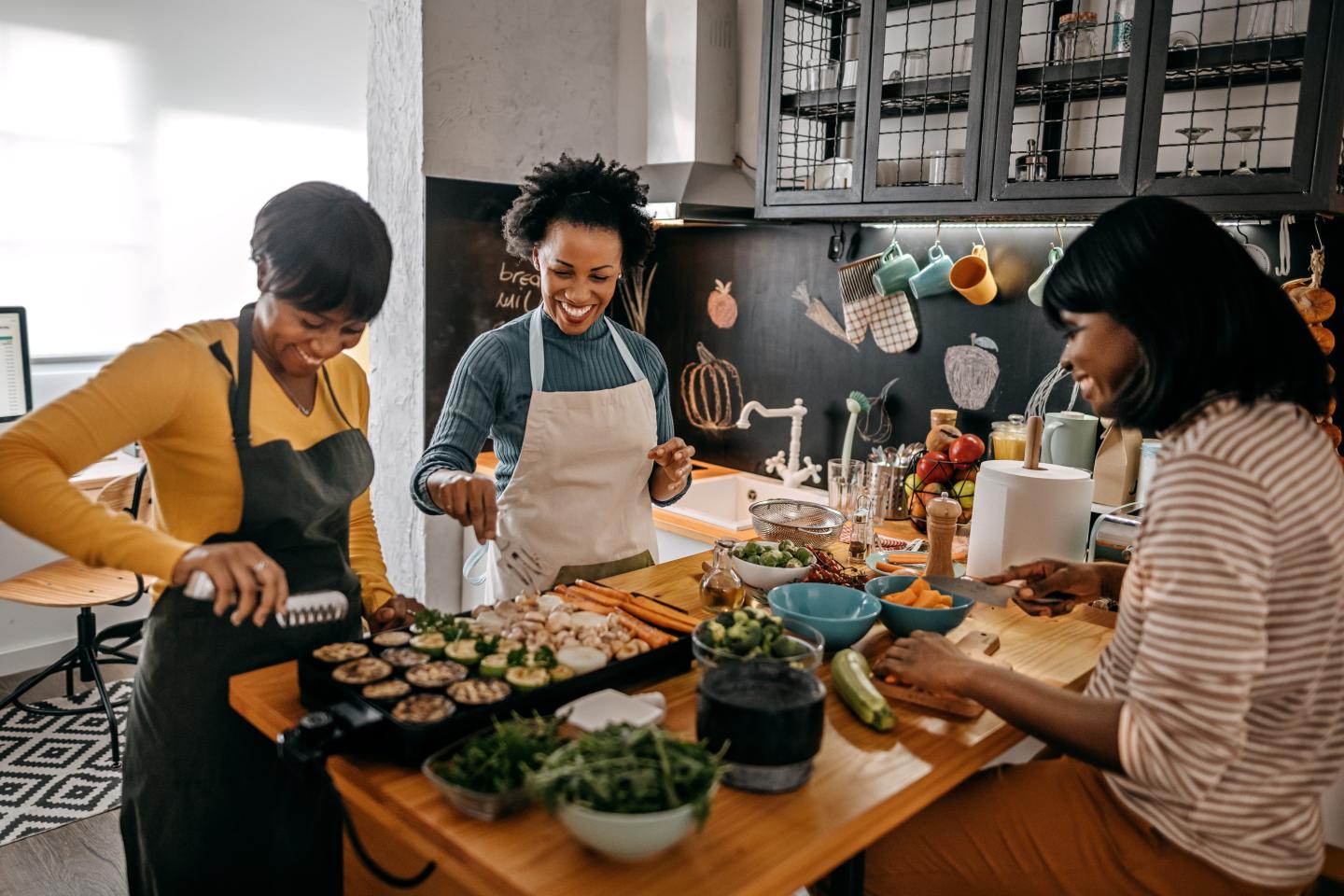 A group of people working on a meal in a kitchen