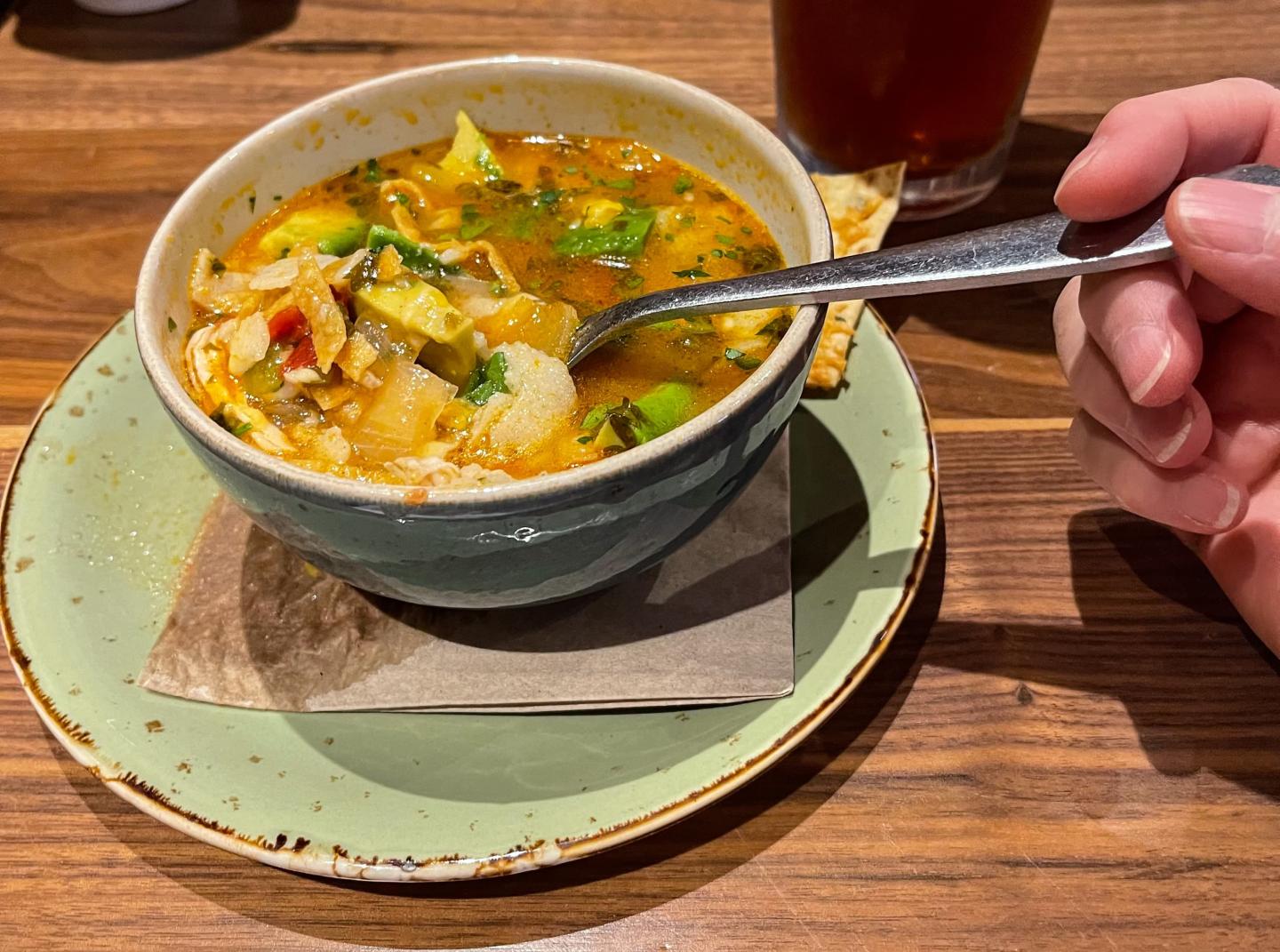 A spoon being dipped into a bowl of soup