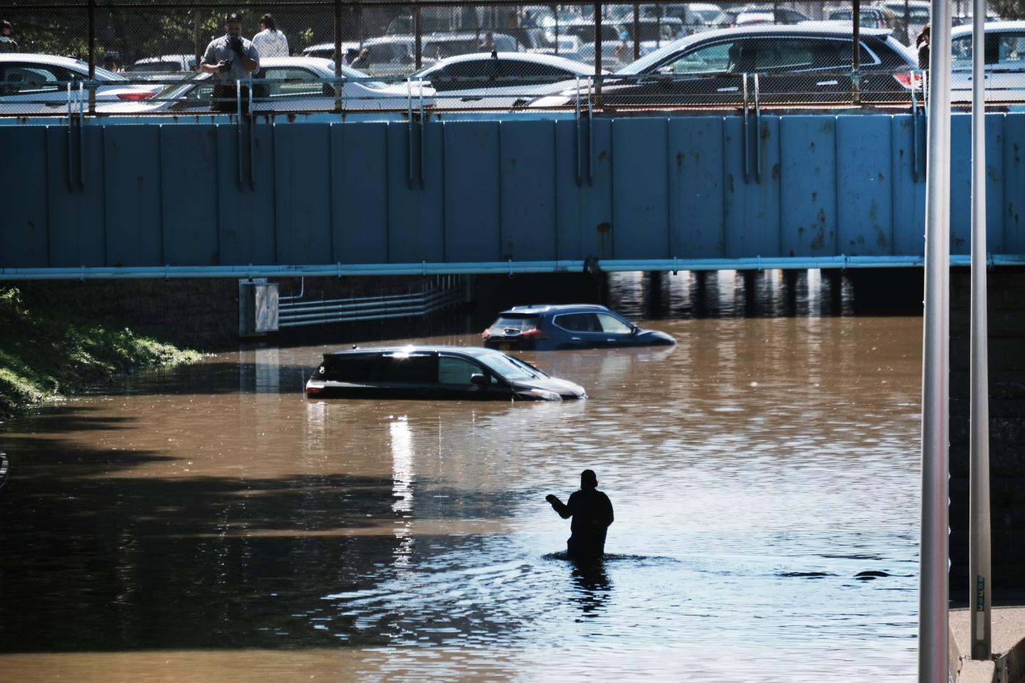 A person wading through flood waters after Hurricane Ida