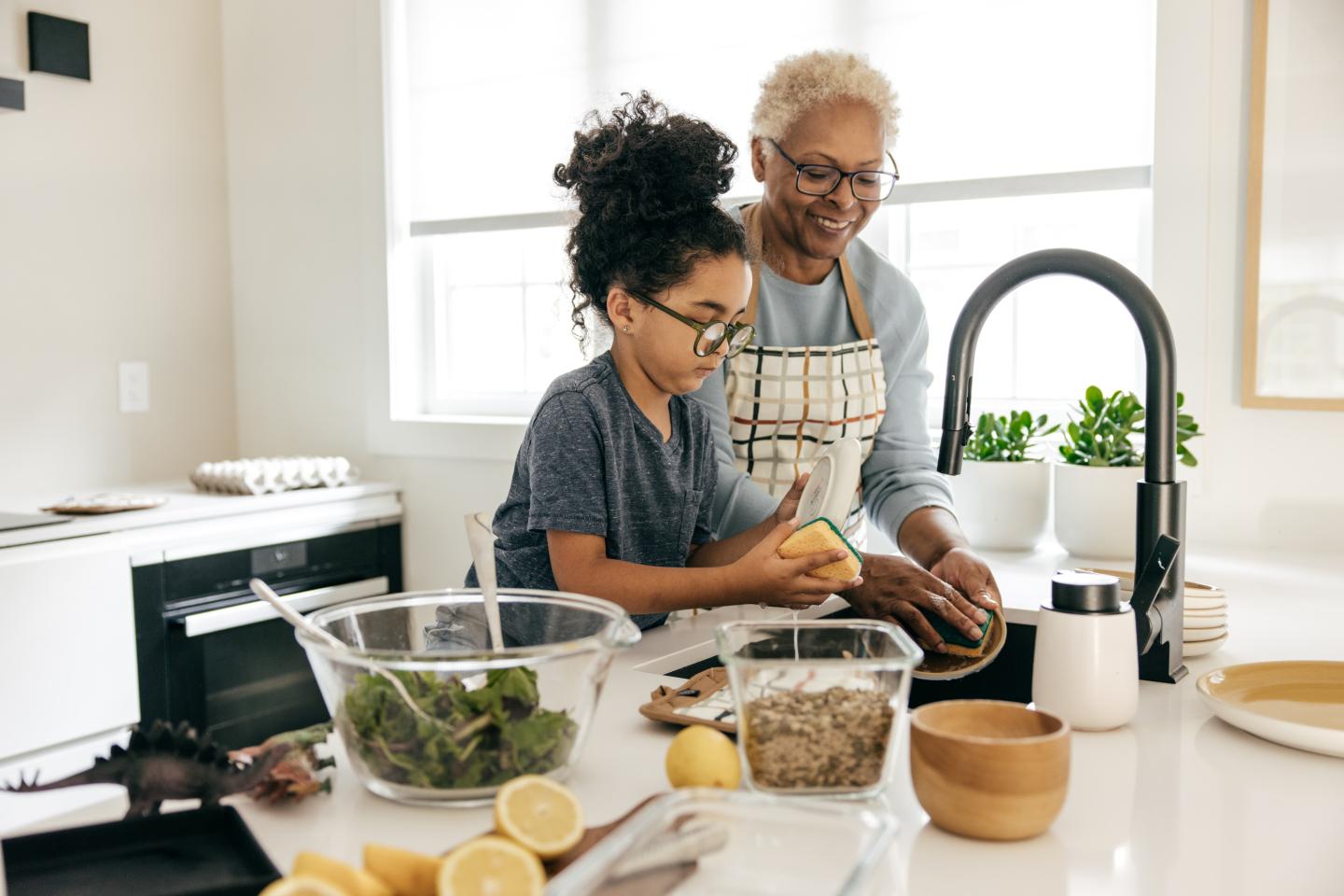 Two generations of cooks working together over a sink