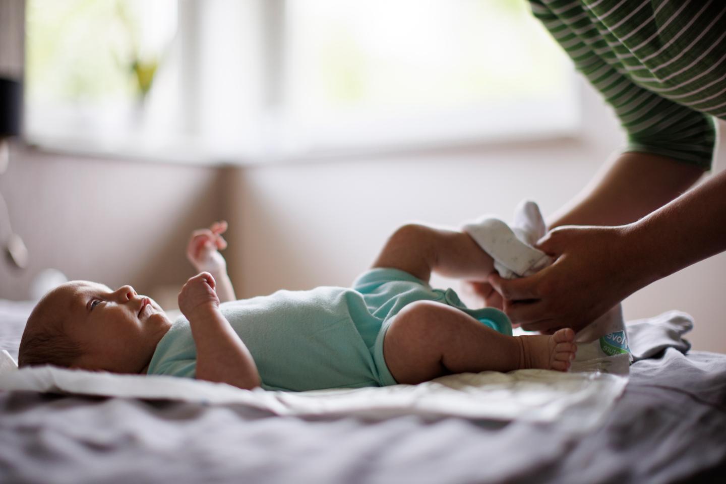 A parent putting booties on a baby after changing