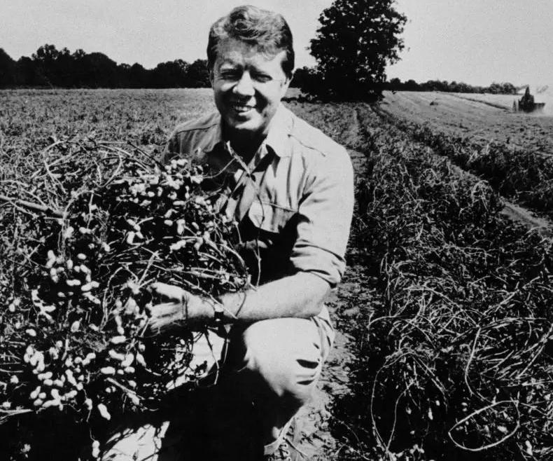 A young Jimmy Carter kneeling on his peanut farm