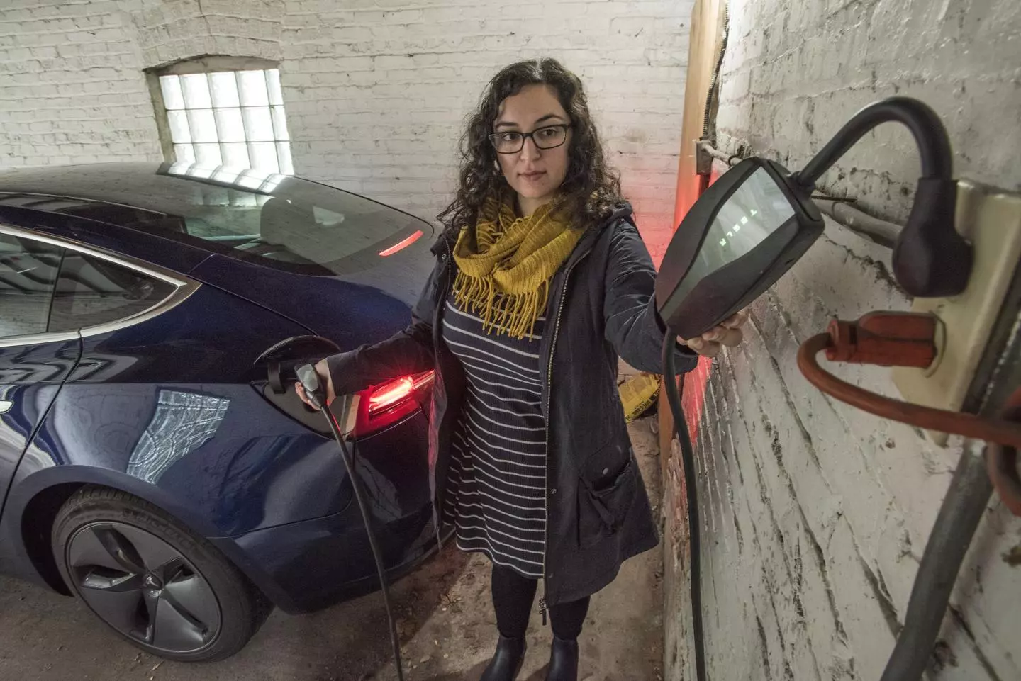 Neda Deylami plugging in her electric car