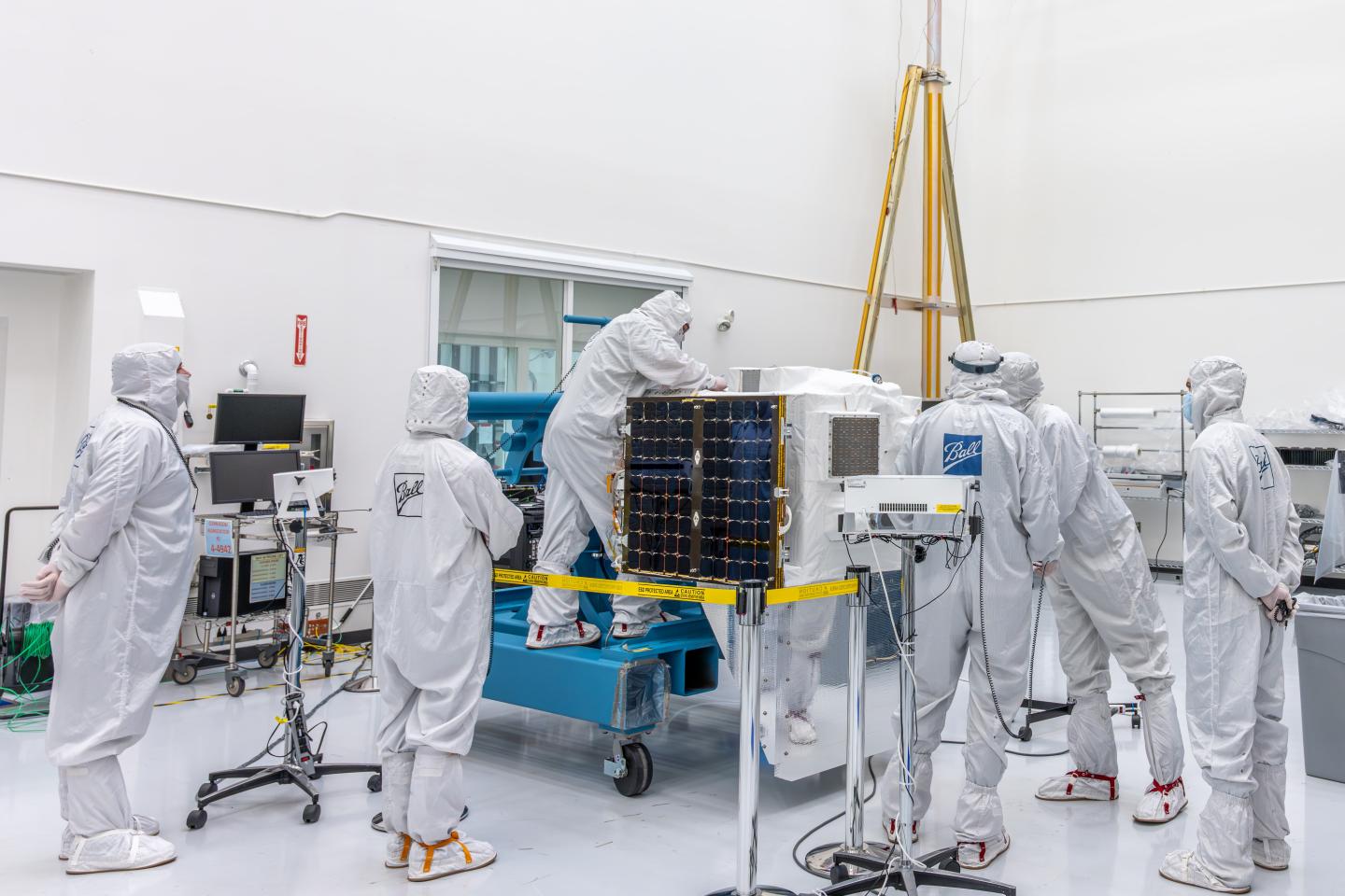 A team of scientists in sterile white jumpsuits from Ball Aeronautics work on MethaneSAT
