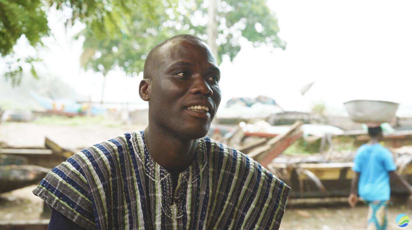 Nana Kweigyah in front of fishing boats