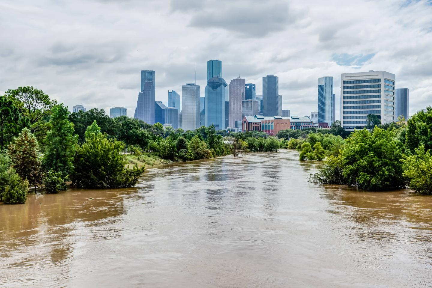 Flooded waters in the foreground with a city skyline in the background