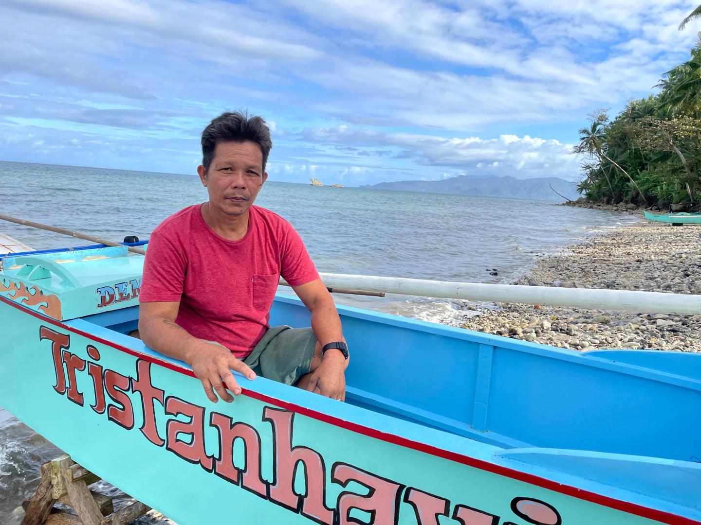 Patrick Quiban sitting in a blue boat