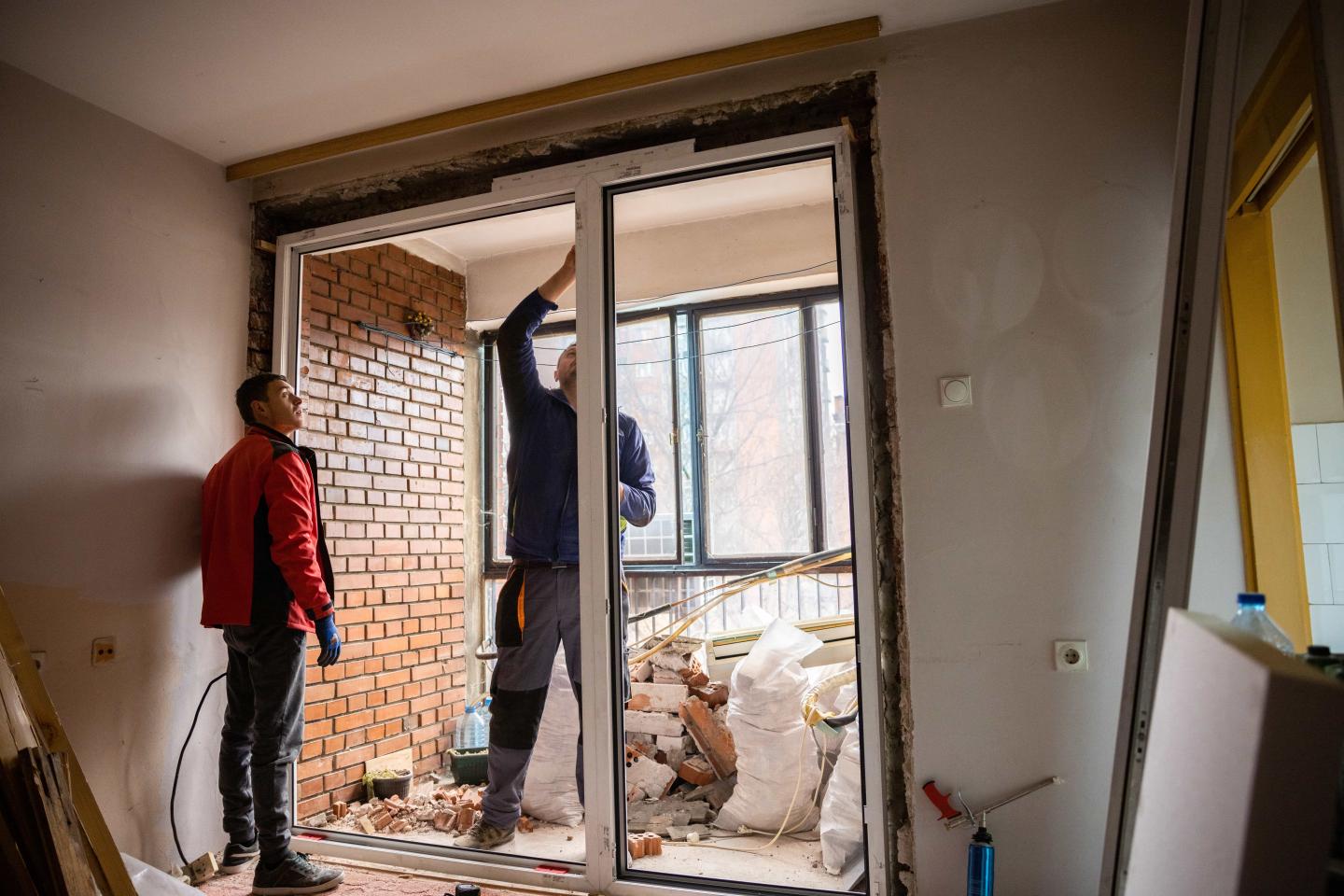 Two people installing new doors