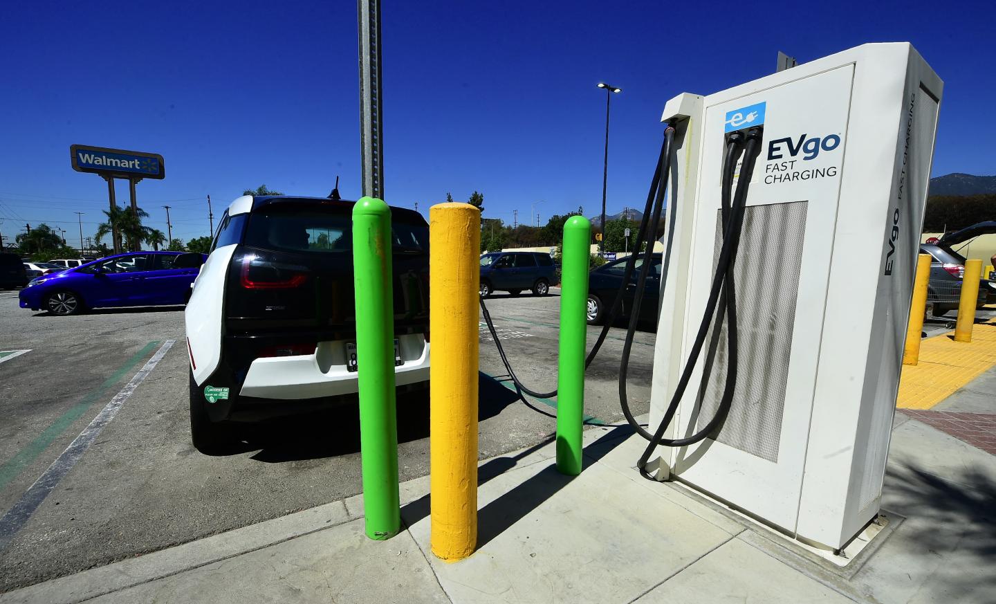 A car parked at an EVgo charging station in a Walmart parking lot