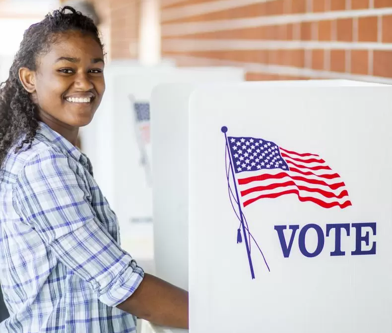 A young adult smiling while voting 