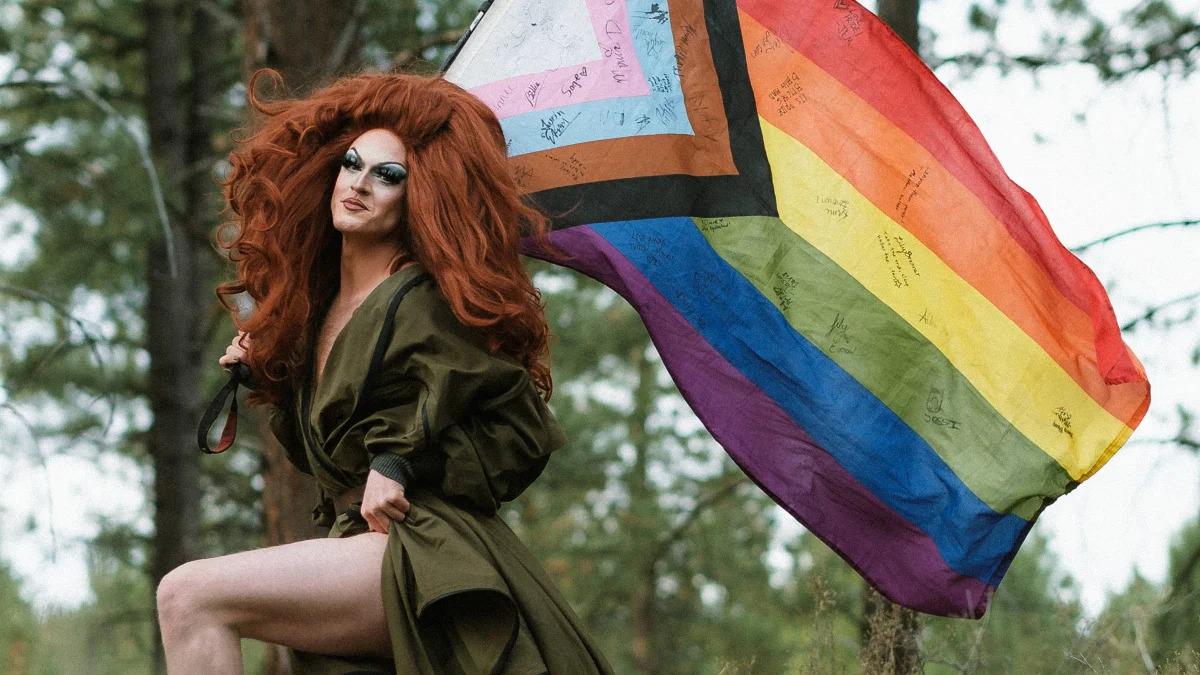 Activist Pattie Gonia holding a Pride flag