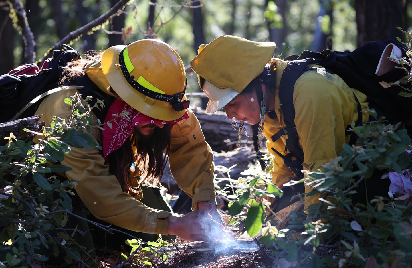 Esak Ordoñez working on a controlled fire with a partner