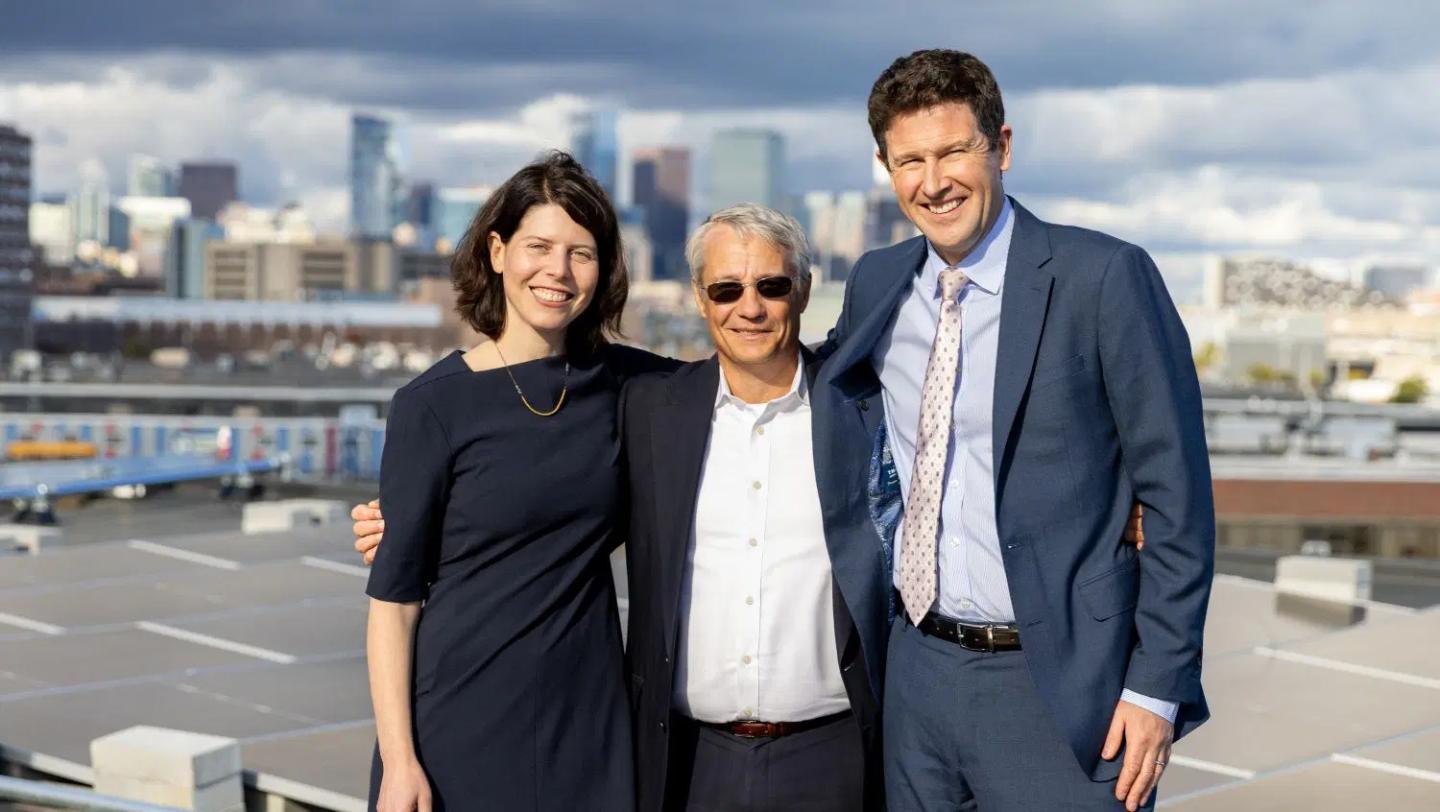 Dr. Anna Goldman, Bob Biggio and Dr. Alastair Bell standing on a roof by solar panels