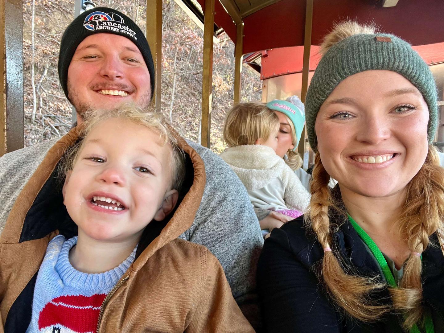 Chelsea Lyons and her husband holding a child on his lap