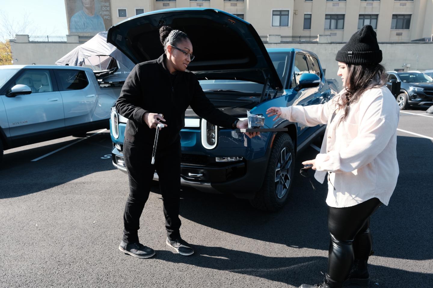 A person is being handed the keys to a Rivian truck